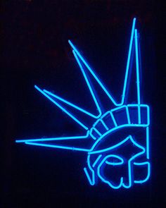 a blue neon sign with the statue of liberty on it's face and hands