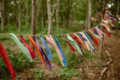 colorful streamers hanging from a rope in the woods