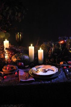 a table topped with candles and plates filled with food