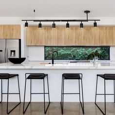 three stools sit in front of the kitchen island