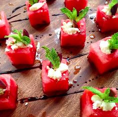 watermelon cubes with mint garnish on a wooden table, ready to be eaten