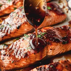 a spoon drizzling barbecue sauce onto salmon