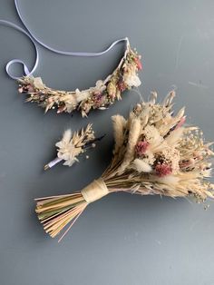 two dried flowers are laying on the floor next to a string and some wire hangers