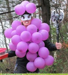 a person in costume holding up some purple balloons