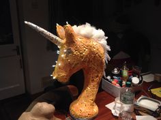 a wooden table topped with a fake unicorn head