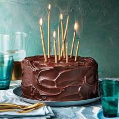 a chocolate cake sitting on top of a table with candles in the middle of it