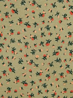 an apple print fabric with red and green flowers on it's side, in the background