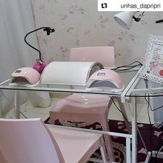 a glass table topped with pink chairs next to a laptop computer on top of a desk