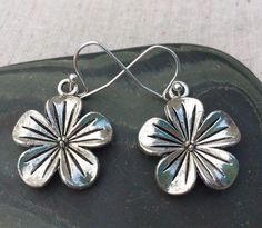 These earrings are beautifully adorned with a dimensional flower design.  Made from allergy free plated silver.The charm measures 3/4". They are lightweight so they are very comfortable.I have the matching necklace in my shop if you would like the whole set.https://www.etsy.com/listing/163102810/silver-flower-pendant-silver-flowerPlease visit the rest of my shop, as I have many lovely adornments to look at and covet. Simple Silver Earrings Flower, Hypoallergenic Flower-shaped Earrings For Anniversary, Silver 3d Flower Earrings, Nickel Free Flower Earrings For Anniversary, Nickel-free Flower Earrings For Anniversary, Adjustable Nickel-free Flower Earrings, 3d Flower Earrings For Anniversary, Anniversary Flower Earrings With Ear Wire, Hypoallergenic Flower Shaped Earrings For Anniversary