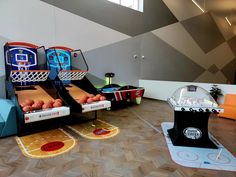 an indoor basketball court with arcade machines and balls on the floor in front of it