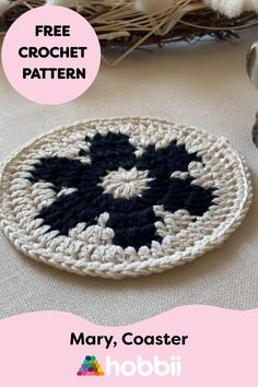 a crocheted black and white plate sitting on top of a table next to a basket