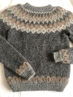 a gray sweater with brown and white designs on it