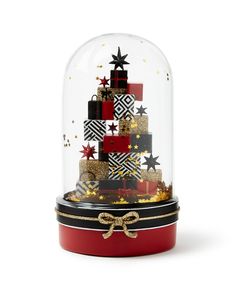 a christmas tree under a glass dome with gold and black stars on it's sides