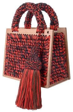 a red and black handbag with a tasselled handle