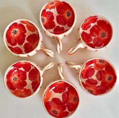 six red and white bowls with flowers on them are arranged in the shape of a flower