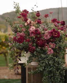 a vase filled with lots of flowers on top of a table