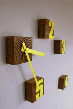 three wooden blocks with yellow tape on them are hanging from the wall and numbered numbers