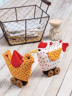 two small wooden chickens sitting on wheels