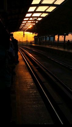 people are waiting for the train at sunset