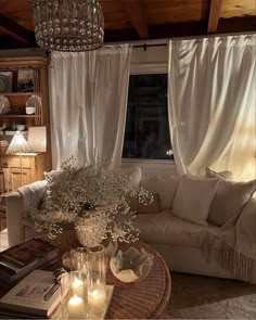 a living room filled with furniture and a chandelier hanging over it's windows