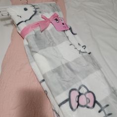 a hello kitty blanket laying on top of a bed