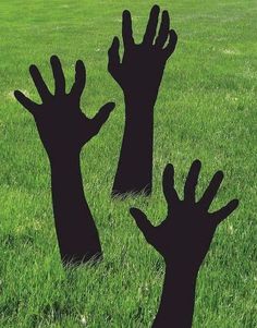 two silhouettes of hands reaching up in the grass