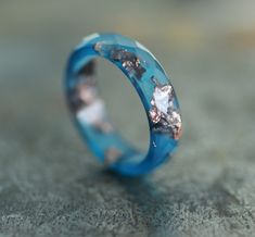 * ONE blue resin ring from my resin jewelry collection * resin band ring - 4-5 mm/0.16 - 0.19 inches/width  * thickness - about 2.3 - 2.5 mm/about 0.09 inches/ * faceted ring with unique flakes pattern * natural color ring - ocean blue ring with copper flakes/rose gold leaf * resin ring men and women, unisex   You can see the other resin rings from the collection here: https://www.etsy.com/shop/ARTISUNtis?ref=seller-platform-mcnav&section_id=15714637 Features: * Hypoallergenic ring (suitable for the people with metal allergy) * For everyday and for special occasions * Perfect gift for you or for the special one in your life  * Stacking ring - you can wear it on its own or stacked with some other rings * Simple and elegant design * Comfort fit ring for wearing * Lightweight ring - pleasant Unique Blue Resin Rings, Blue Resin Rings For Gifts, Blue Resin Rings Perfect As Gifts, Blue Resin Rings Perfect For Gifts, Handmade Blue Resin Rings, Resin Rings, Faceted Ring, Unique Birthday Gift, Blue Ring