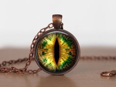 a necklace with an image of a green and yellow cat's eye on it