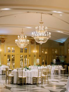 an elegant ballroom with chandeliers and tables