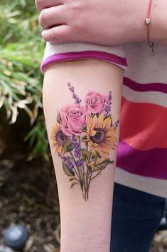 a woman's arm with sunflowers and roses tattooed on her left arm