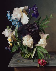 a vase filled with lots of flowers on top of a table