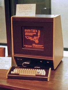 an old computer sitting on top of a wooden desk