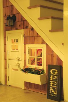 a dog house with flowers in the window and a sign on the door that says welcome