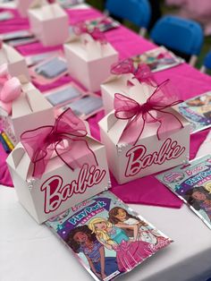 barbie birthday party favors with pink bows and candy bar wrappers on the table top