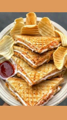 a white plate topped with four quesadillas and chips