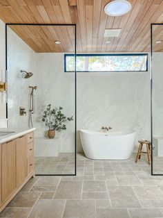 a bathroom with a bathtub, sink and mirror in it's center wall