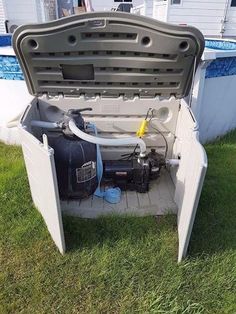 an open trunk on the ground in front of a house