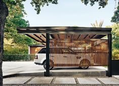 a car is parked in front of a wooden structure with an awning over it