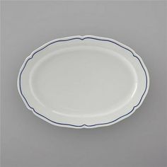 a white plate with blue trim on the rim is shown in front of a gray background