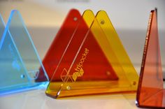 three triangular shaped plastic signs sitting on top of a table