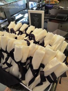 several pieces of white and black cloth tied together on a table with a plaque in the background