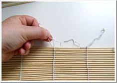 someone is stitching together some white string to make a wall hanging or window decoration