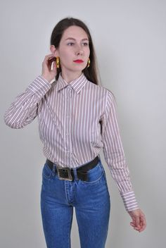 "White striped shirt, vintage formal blouse, Size M Welcome to TARASCOMMON.ETSY.COM Unique clothing from the 20th century. Model tall 170cm. Size: M. Sleeve - 60cm / 23.62inch; Width - 40cm / 15.74inch; Length - 67cm / 26.37inch. COTTON. All measurements are taken seam to seam while lying flat. This item is vintage, so it can have some defects. Additional photos can be send! We are glad that you are interested in lots that we sell. Wish you a good shopping! FOLLOW US : Instagram:https://www.inst Classic Formal Blouse With Striped Collar, Fitted Vertical Stripes Office Shirt, Classic Striped Shirt For Fall, Retro Button-up Formal Shirt, Retro Button-up Shirt For Formal Occasions, Classic Fitted Brown Blouse, Fitted Button-up Blouse With Vertical Stripes, Vintage Brown Shirt For Workwear, Classic Vertical Stripes Blouse For Fall