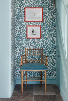 a blue chair sitting in front of a wall with pictures on it