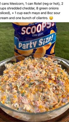 an image of a bowl of party size corn salad on a table with a bag of scoops in the background