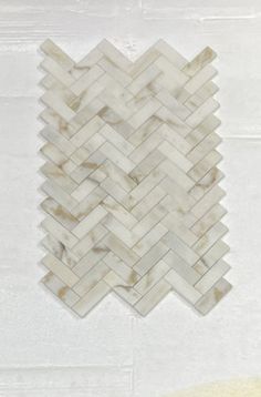 a white marble herringle tile pattern on the wall