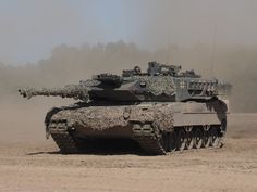 an army tank is driving through the desert