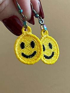 a pair of smiley face earrings hanging from a hook