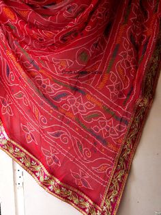 Very beautiful and gorgeous light weight red Georgette tie dye bandhej chunri with zari work. It is decorated with golden flower embroidered lace on all 4 sides. This is a ready to wear dupatta/scarf. It can be used for wedding, wedding rituals, party, bridesmaid gift, lehenga dupatta, Indian functions or events. Dimension: Length: 2 meter Width: 1.2 meter Transitional Red Dupatta With Gota Work, Festive Bohemian Bandhani Saree, Red Zari Work Saree For Festival, Red Saree With Zari Work For Festival, Bohemian Red Traditional Wear With Bandhani Print, Red Bohemian Traditional Wear With Bandhani Print, Red Bohemian Saree For Festive Occasions, Bohemian Traditional Wear With Bandhani Print For Festivals, Bohemian Bandhani Traditional Wear For Festivals