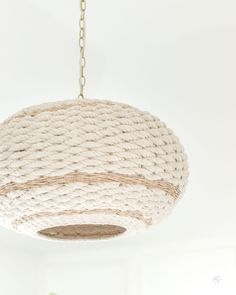 a white rope light hanging from a ceiling in a living room or dining room area